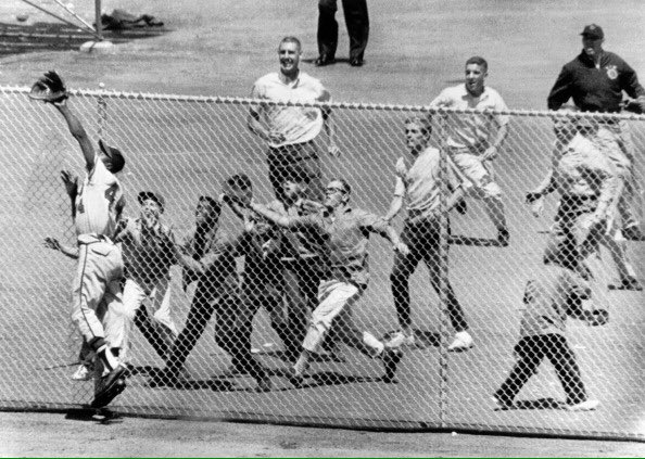 Photo of Hank Aaron of the Atlanta Braves keeping Giants fans from getting a home run ball in 1961. 