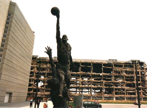 Photo of "The Spirit" statue outside of the United Center with a demolished Chicago Stadium in the background. 