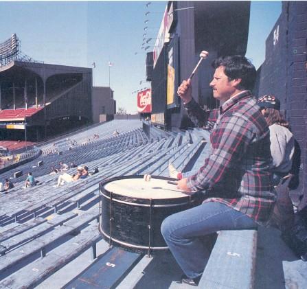 Photo of Cleveland Indians fan John Adams banging his drum from the last row of the Cleveland Municipal Stadium bleachers.