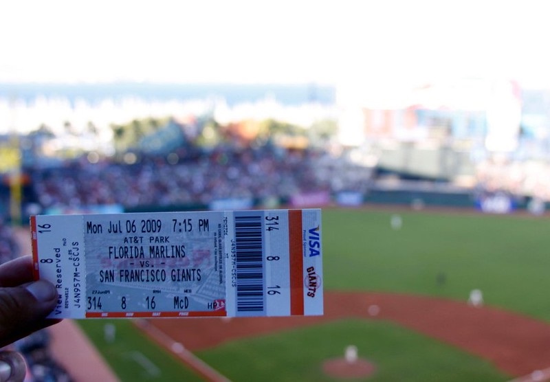 Stock photo of a baseball fan holding a ticket stub to a San Francisco Giants game at AT&T Park.