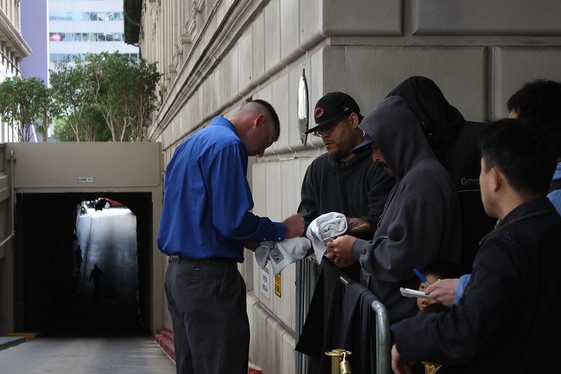 Photo of baseball players signing autographs outside of a hotel.