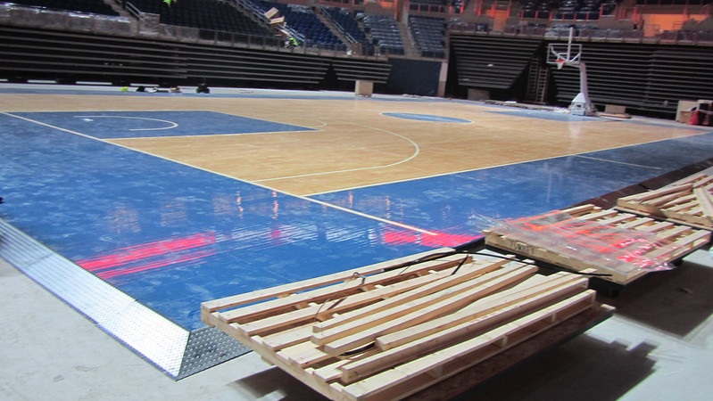 Photo of a basketball court being installed inside an arena.