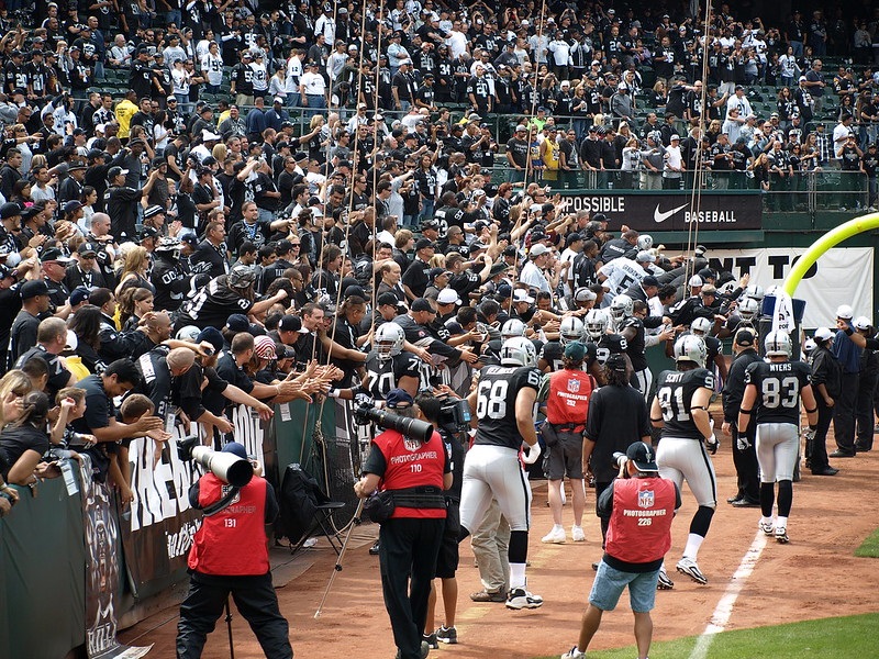 Photo of Oakland Raiders fans in the Black Hole during an Oakland Raiders home game.