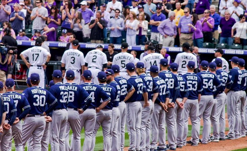 Photo of Colorado Rockies players standing during the national anthem at Coors Field.