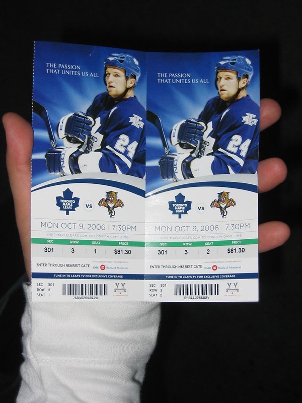 Photo of a hockey fan holding Toronto Maple Leafs tickets.