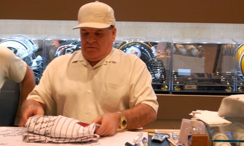 Photo of Pete Rose signing autographs during an in store appearance.