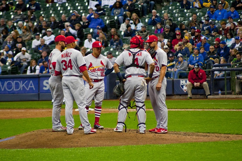 Photo of St. Louis Cardinals players meeting on the pitcher's mound.