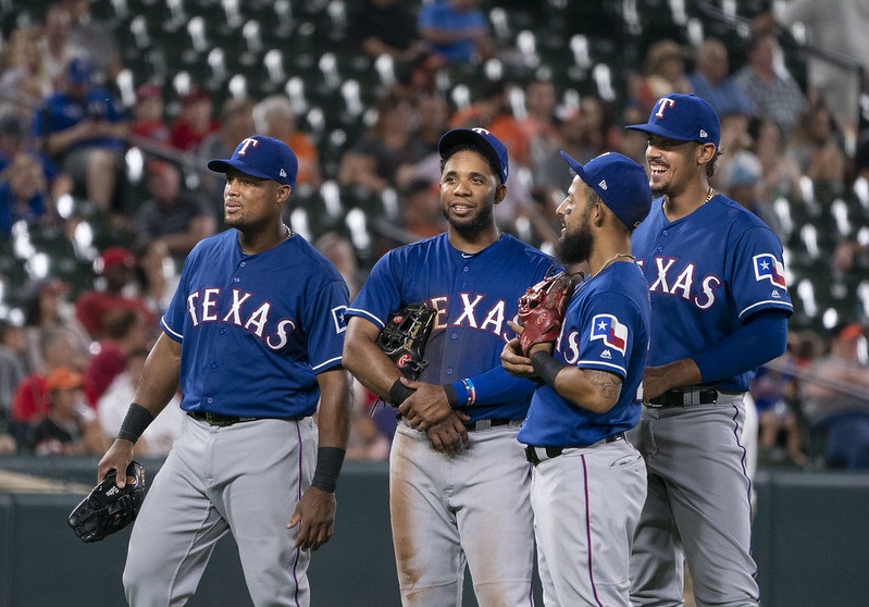 Photo of Texas Rangers players meeting on the pitcher's mound at Globe Life Park in Arlington. 
