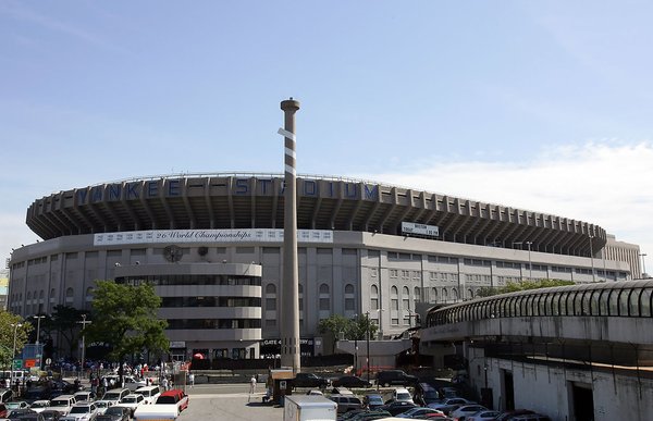 An exterior view of Yankee Stadium with the legendary bat in the parking lot.  