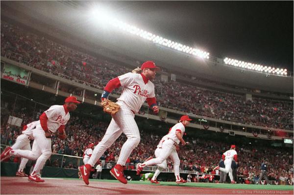 Photo of John Kruk and the Philadelphia Phillies taking the field for a night game.
