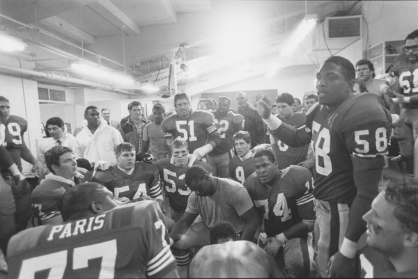 Photo of longtime 49ers Linebacker Keena Turner giving a speech in the locker room. 