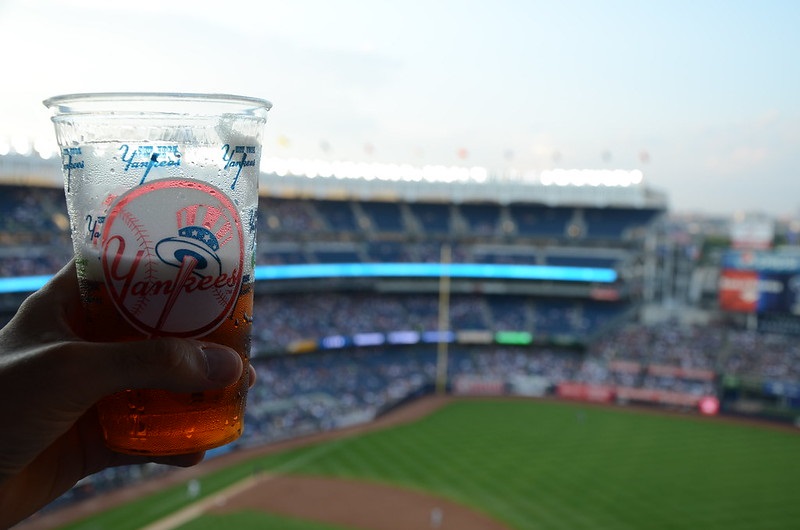 Photo of a baseball fan holding a beer at Yankee Stadium during a New York Yankees game.
