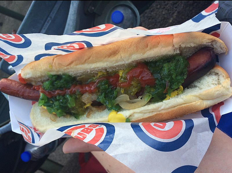 Photo of a fan holding a foot long hot dog at Wrigley Field during a Chicago Cubs home game.