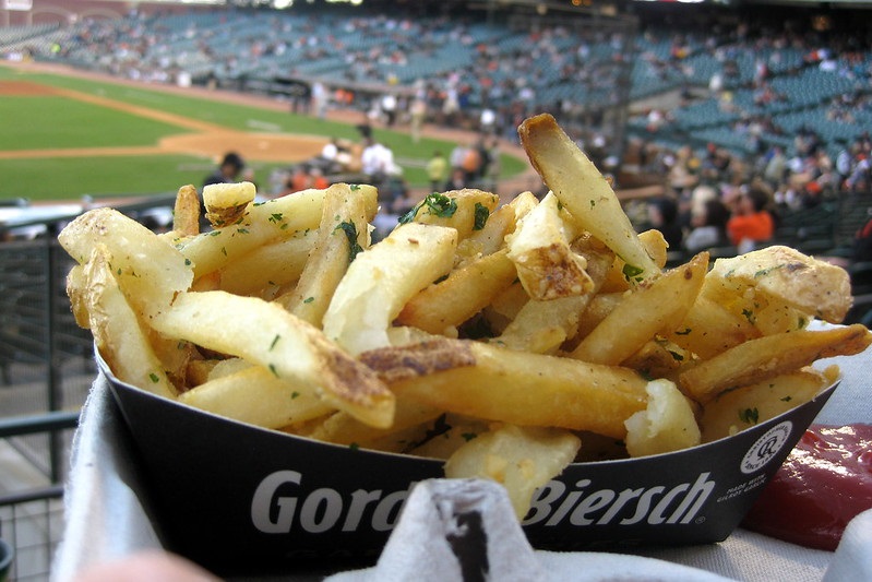 Photo of fan holding Gilroy's garlic fries at AT&T Park during a San Francisco Giants game.
