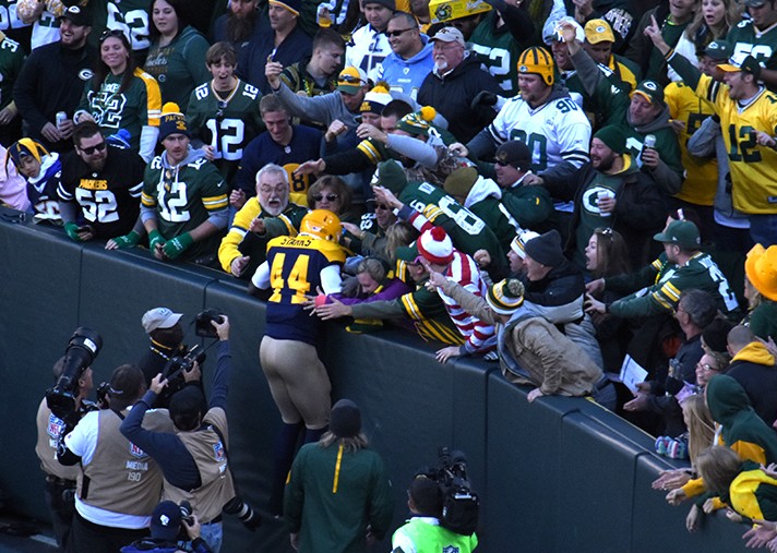 Photo of James Starks doing the Lambeau Leap at Lambeau Field during a Green Bay Packers game.